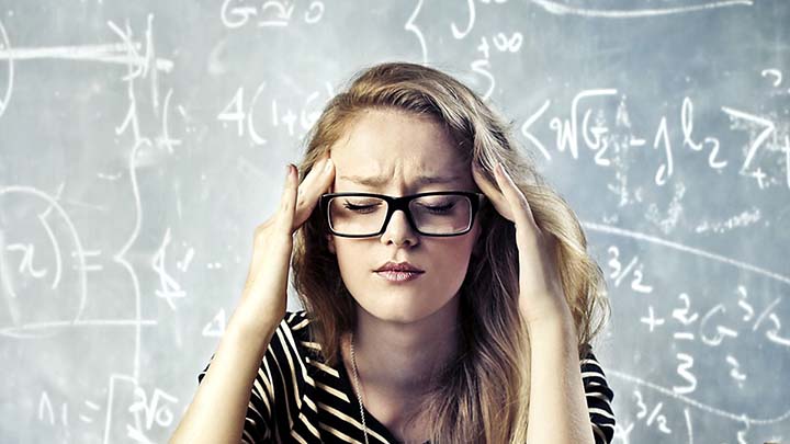 stressaantunut henkilö hieroo ohimoitaan